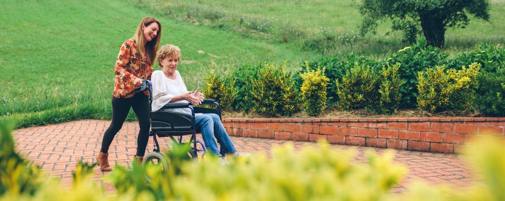 Woman carrying her mother in a wheelchair