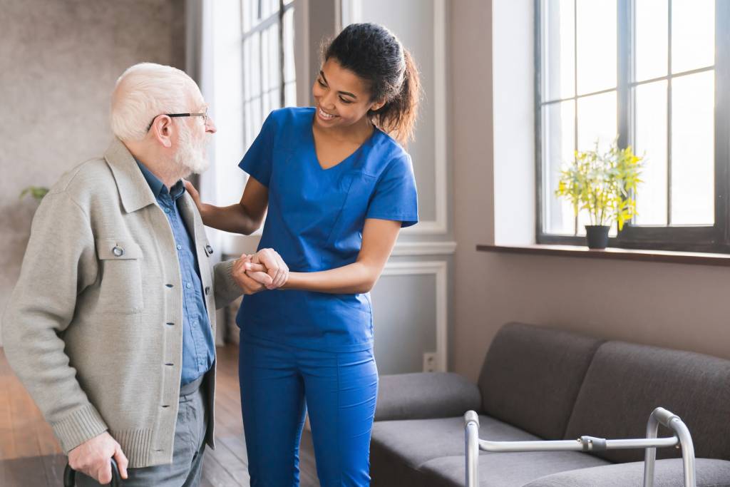 Caregiver holding elder person's hand