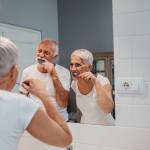 happy senior couple having fun while brushing teeth on their morning routine