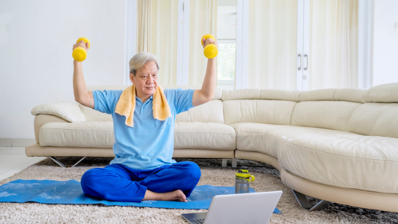 Senior exercising at home using a computer